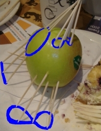 An apple with a circle and a figure 8 frawn on it