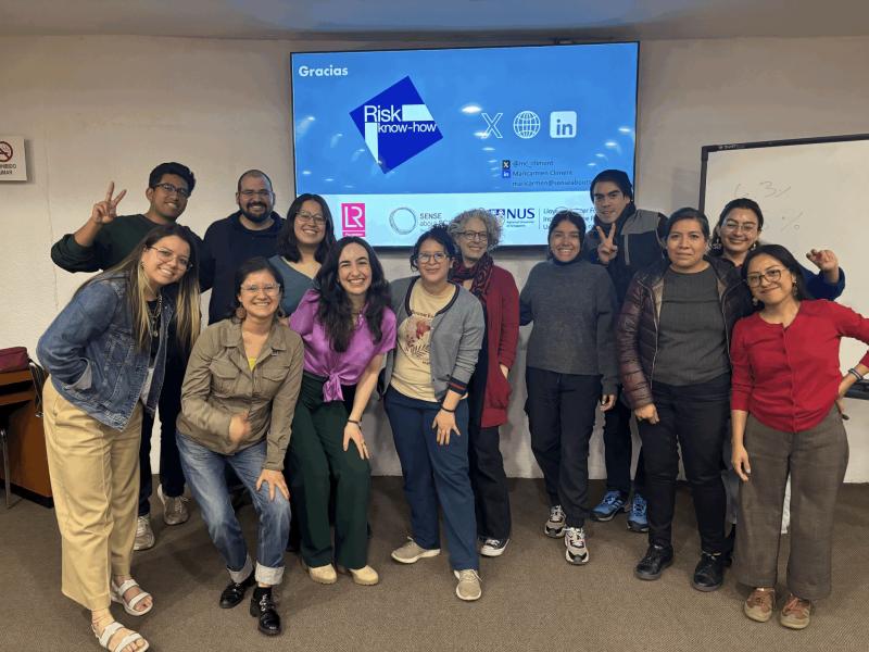 Group of smiling people in front of a screen with thanks from a Risk Know-how presentation
